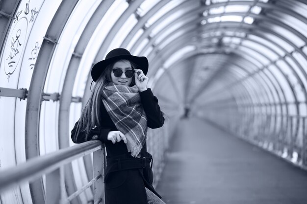 Chica adulta joven en el túnel arquitectónico del puente