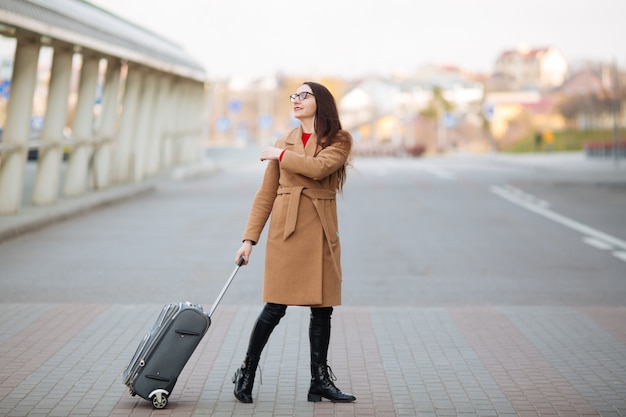 Chica en el aeropuerto internacional, equipaje y esperando su vuelo, vista desde la terminal del aeropuerto.