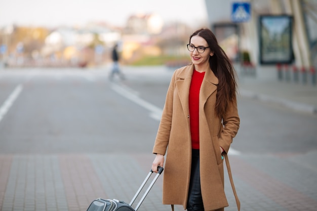 Chica en el aeropuerto internacional, equipaje y esperando su vuelo, vista desde la terminal del aeropuerto.