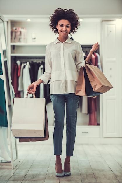 Chica afroamericana con bolsas de compras.