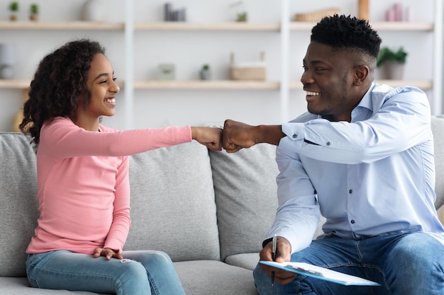 Chica afroamericana feliz dando golpe de puño psicoterapeuta