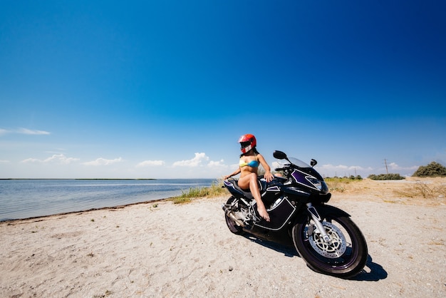 Chica al atardecer cerca de la moto.