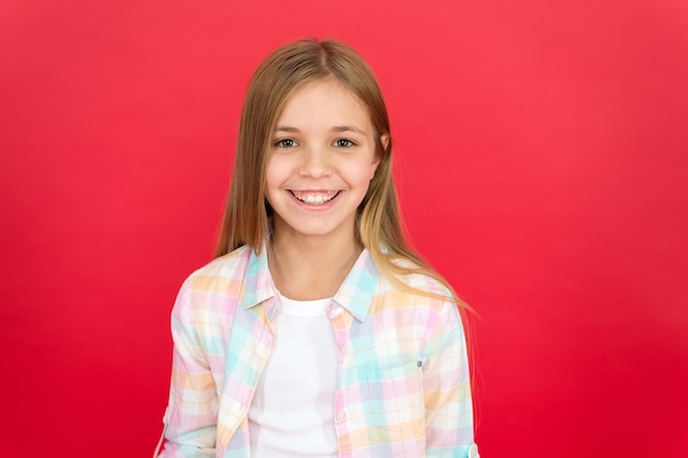 Chica alegre cara sonriente sobre fondo rojo Niño emocional feliz cara sonriente Alegre adorable