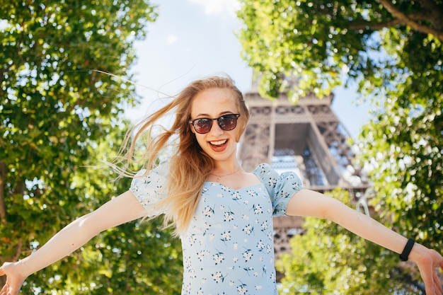 Chica alegre y feliz cerca de la Torre Eiffel en París