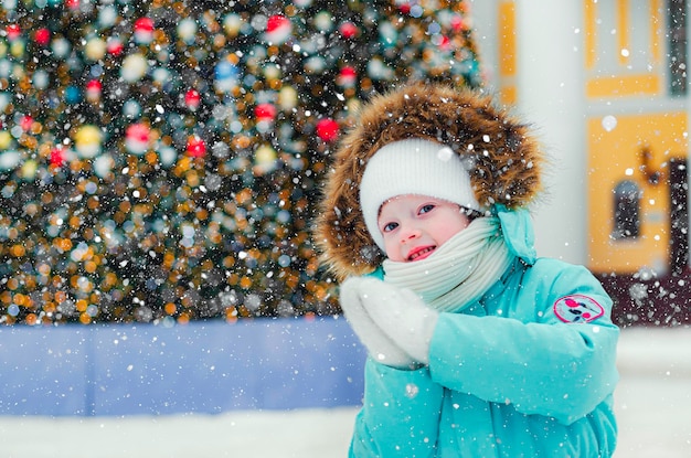 Foto una chica alegre en el fondo de un árbol de navidad