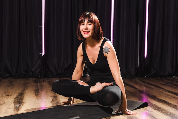 Una chica alegre hace yoga en un elegante estudio.