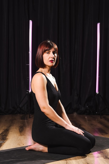 Una chica alegre hace yoga en un elegante estudio.