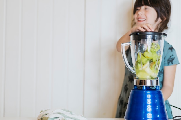 Chica alegre haciendo batido