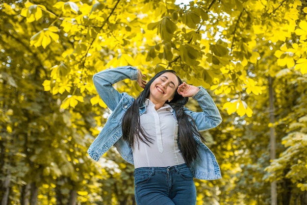 chica alegre con pelo negro en el parque.