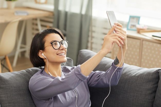 Chica alegre que se conecta por tecnología