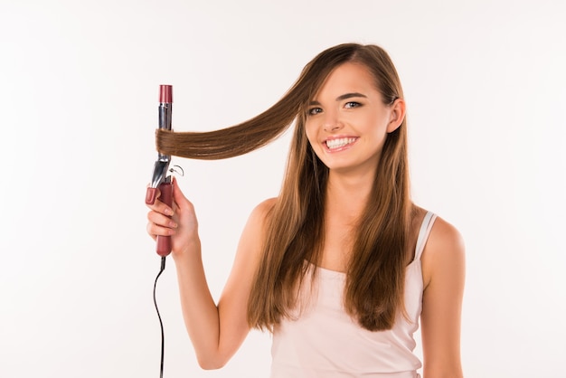 Chica alegre rizando su cabello