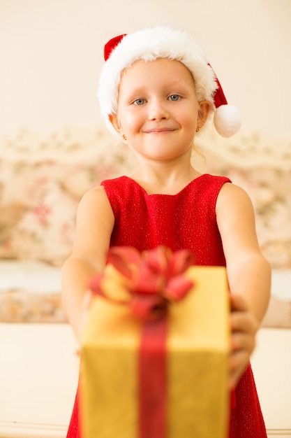 Chica amable complaciente dando regalo de Navidad