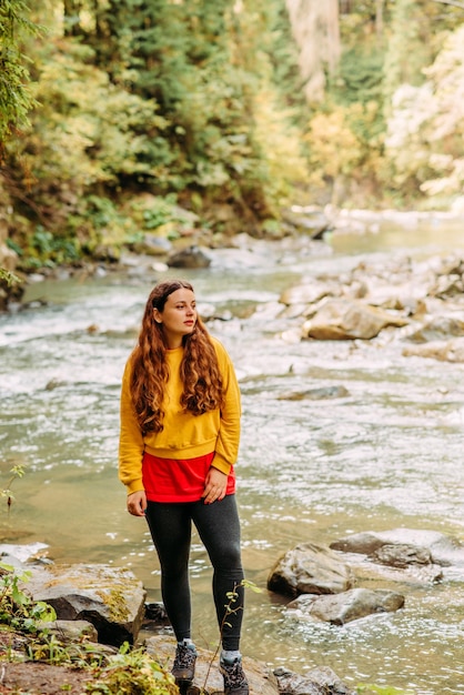 Chica de amarillo en un paseo por las montañas