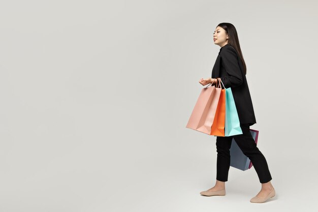 Chica de apariencia asiática con bolsas de papel para comprar