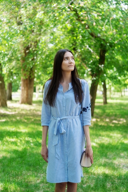 Una chica de apariencia asiática en un paseo por un parque de la ciudad