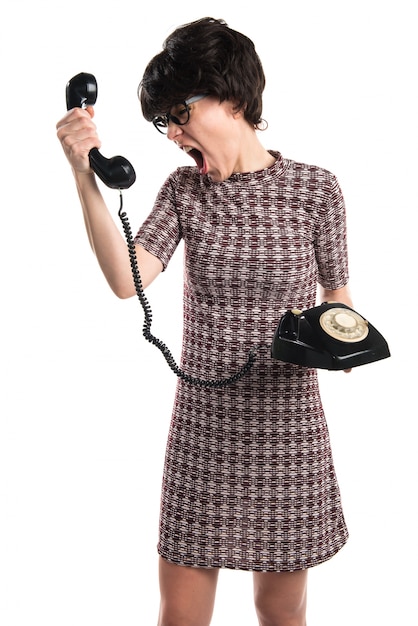 Chica con apariencia vintage hablando con teléfono vintage