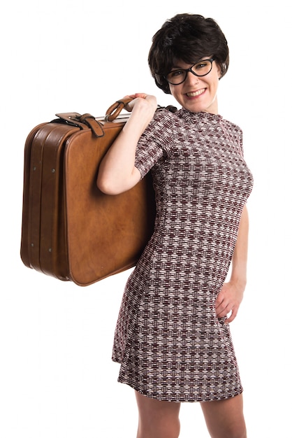 Chica con apariencia vintage sosteniendo una maleta