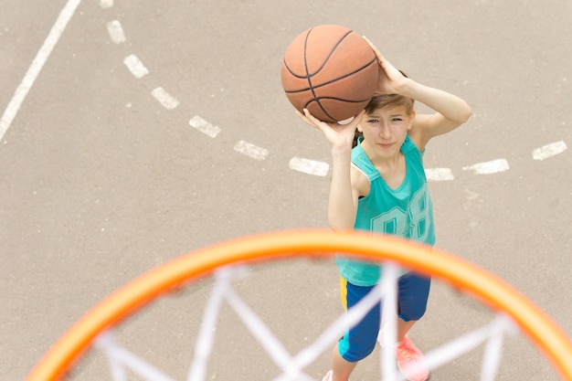 Chica apuntando a la meta en una cancha de baloncesto