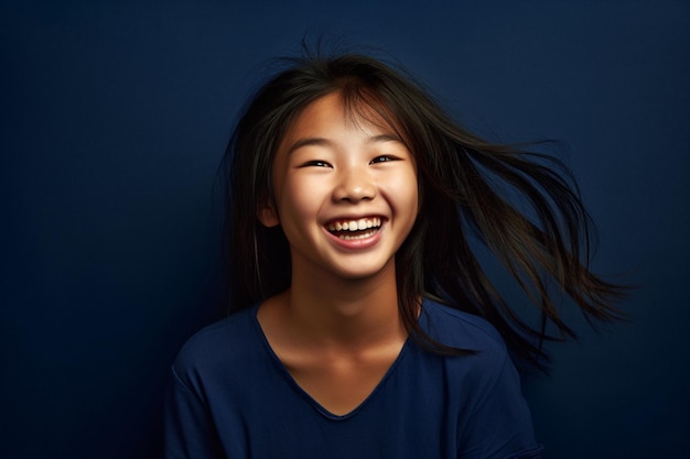 Chica asiática adolescente sonriente contra un fondo azul marino sólido