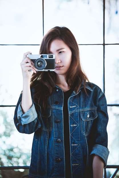 Chica asiática con cámara retro