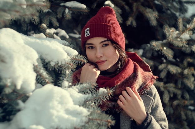 Chica asiática cerca de un árbol nevado