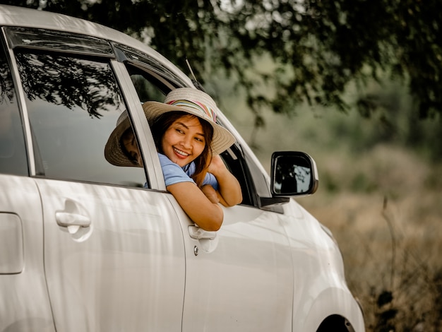Chica asiática en coche con el concepto de viaje de mapa