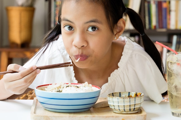 Chica asiática comiendo fideos instantáneos de Corea