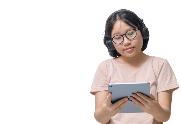 chica asiática descansando en el sofá con una tableta digital usando auriculares inalámbricos viendo películas en Internet