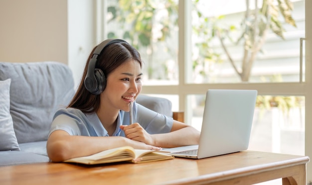 Chica asiática estudiante de aprendizaje en línea clase de estudio en línea videollamada zoom maestra chica asiática feliz aprender inglés en línea con computadora portátil