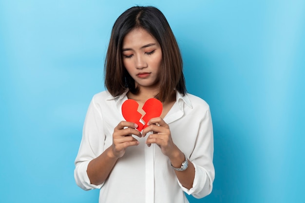 Chica asiática con forma de corazón rojo roto