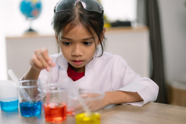 Una chica asiática haciendo experimentos químicos en el laboratorio.