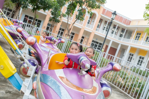 Chica asiática juega en el patio de recreo con diversiónFeliz tiempo de niño