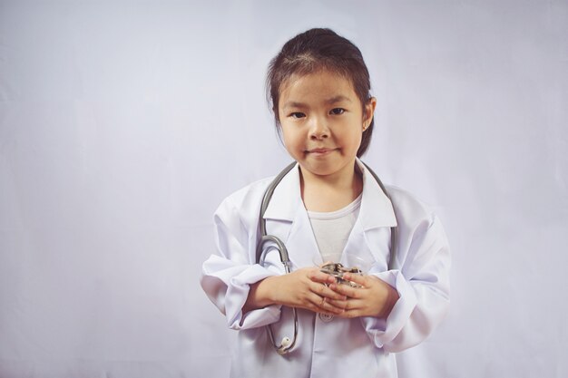 Chica asiática jugando como dinero de cuidado médico en taza