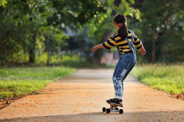 Chica asiática jugando Surf Skate Board en el parque Deporte Actividad estilo de vida concepto saludable y ejercicio