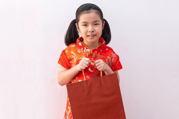 Chica asiática llevar cheongsam mantenga bolsa de papel comercial.