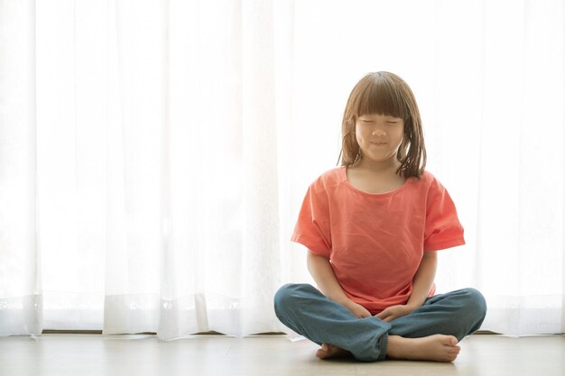 Chica asiática meditando adorable kidxA