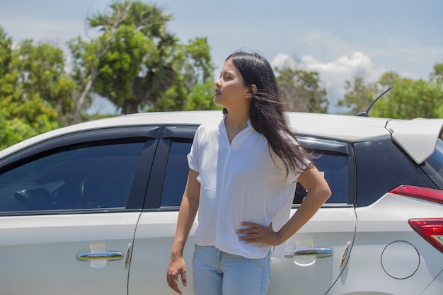 Chica asiática de pie en el coche en la calle