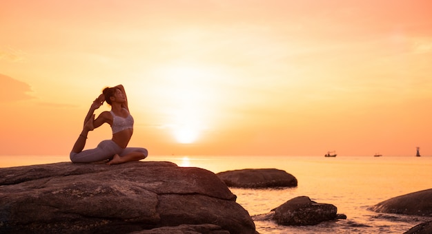 Foto chica asiática practica yoga en la playa amanecer mañana día