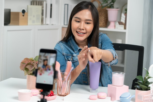 Chica asiática revisando el producto de crema hidratante para hacer que la piel brille Stratagem