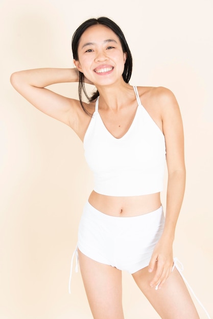 Chica asiática en ropa interior sonriendo y mostrando su cuerpo orgullosa de su cuerpo