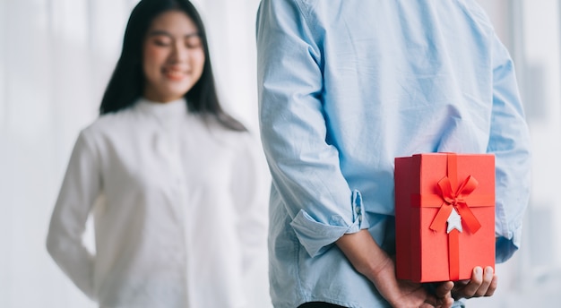 Chica asiática se siente feliz y sorprendida de recibir regalos de su novio el día de San Valentín