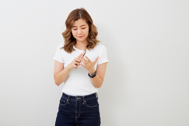 Chica asiática con smartphone en pared gris