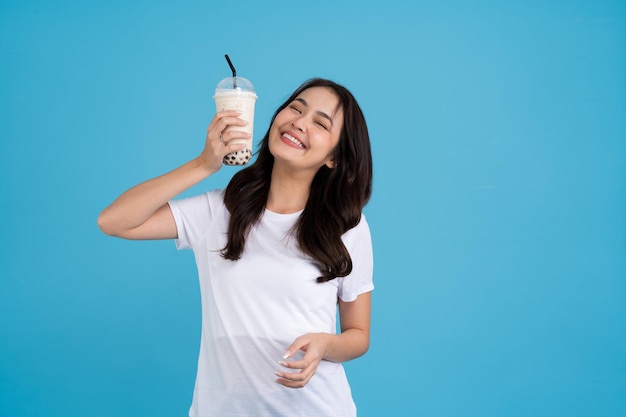 Chica asiática sosteniendo una taza de té con leche de perla con una sonrisa