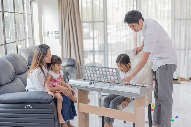 Chica asiática tocando el piano con su padre