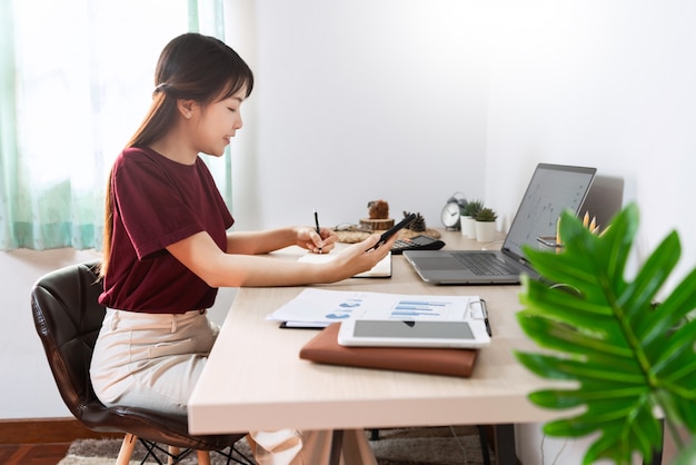 Chica asiática trabajando remotamente desde casa