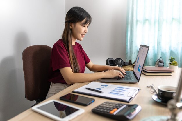 Chica asiática trabajando remotamente desde casa