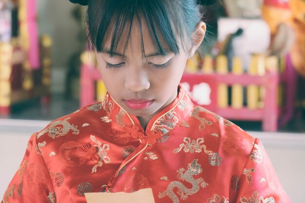 Chica asiática en vestido chino Lectura en papel para predecir el futuro.