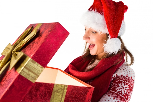 Chica asombrada abriendo un mágico regalo de navidad