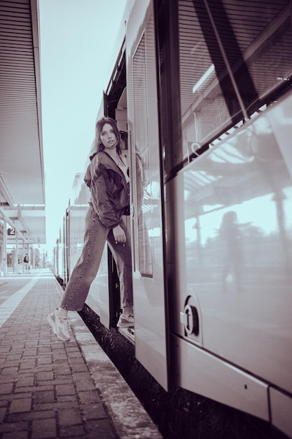 Chica de aspecto caucásico saltando al tren en el último minuto antes de la salida