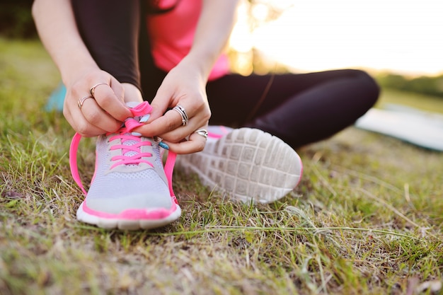 Chica ata los cordones de las zapatillas de deporte